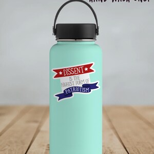 A vinyl sticker with a patriotic design. A red banner at the top reads "Dissent" between two stars; gray text in the middle reads "is the highest form of;" and a blue banner at the bottom reads, "Patriotism." Shown on a teal water bottle.