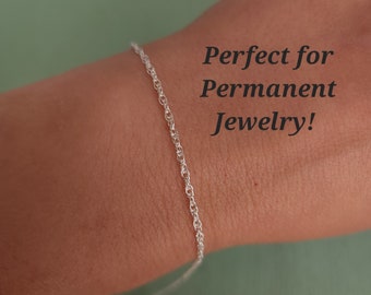 Könnte beinhalten: Ein silbernes Kettenarmband am Handgelenk einer Person. Das Armband ist dünn und zart und perfekt für den täglichen Gebrauch. Der Text "Perfect for Permanent Jewelry!" ist auf dem Bild zu sehen.