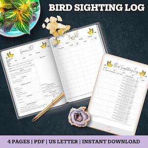 May include: A bird sighting log with the title "Bird Sighting Log" at the top. The log includes pages for species ID and a life list, along with a digital tablet displaying a similar layout. A gold pen and a decorative stone are also present.