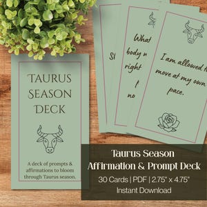 Könnte beinhalten: Ein Kartenset Taurus Season Deck in Salbeigrün mit schwarzen Strichzeichnungen eines Stiers und einer Rose. Die Karten zeigen Text, darunter Taurus Season Deck, I am allowed to move at my own pace und Prompts. Jede Karte misst 7 cm mal 12 cm.