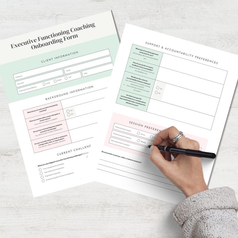 May include: Two white sheets of paper with the text "Executive Functioning Coaching Onboarding Form" in a light green and pink colour scheme. The forms include sections for client information, background information, and session preferences. A hand is holding a pen, filling out the form.
