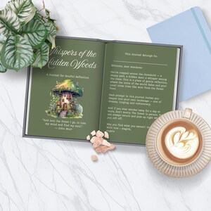 May include: An open journal titled "Whispers of the Hidden Woods" with a forest-themed illustration. The journal is on a marble surface, next to a cup of coffee with latte art and a small plant.