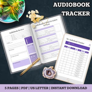 May include: An open notebook and a tablet display audiobook trackers with purple accents. The notebook pages include sections for reviews and a list of audiobooks to listen to. The tablet shows a grid for tracking listening progress. The words "AUDIOBOOK TRACKER" are at the top.
