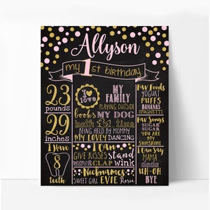 May include: A black chalkboard with gold and pink glitter dots. The text "Allyson my 1st birthday" is written in pink and gold glitter. The chalkboard lists details about the child's first year, including weight, height, favorite foods, songs, and nicknames.