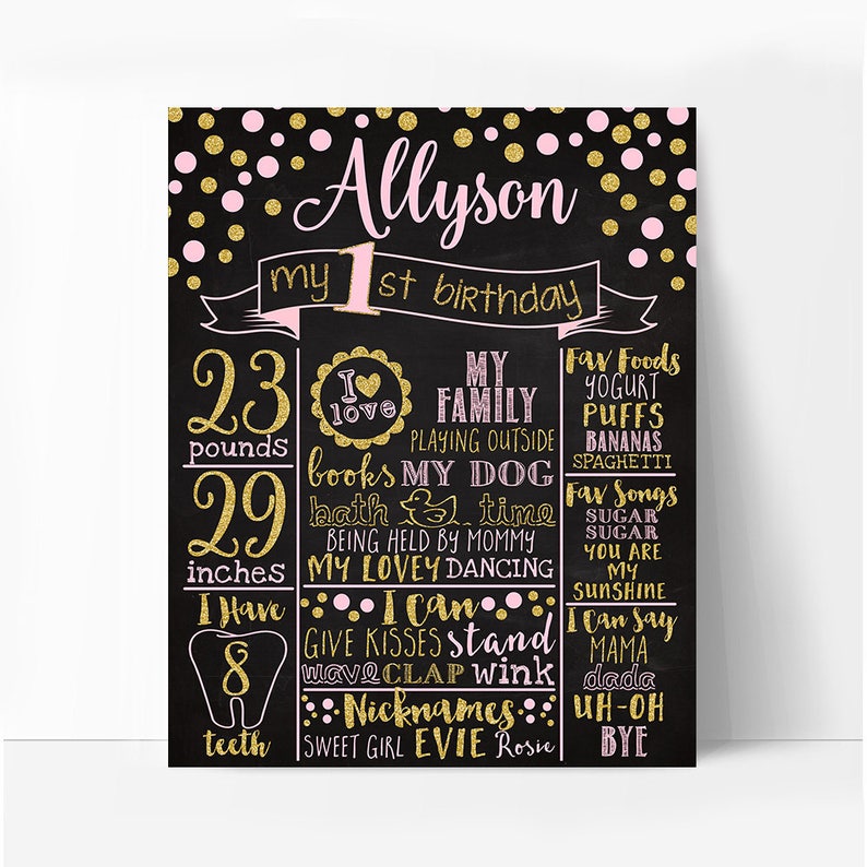 May include: A black chalkboard with gold and pink glitter dots. The text "Allyson my 1st birthday" is written in pink and gold glitter. The chalkboard lists details about the child's first year, including weight, height, favorite foods, songs, and nicknames.