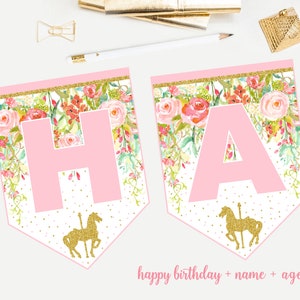 May include: Pink and gold floral birthday banner with the letters "HA" in pink. The banner has a gold glitter trim and a gold carousel horse at the bottom.