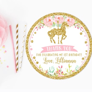 May include: Round pink and gold thank you sticker with a gold glitter carousel horse and floral design. The text reads "Thank you for celebrating my 1st birthday! Love, Lillianna".