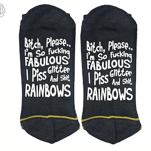 May include: Two black ankle socks with the text "Bitch, Please.. I'm So Fucking FABULOUS I Piss Glitter And Shit RAINBOWS" in white. The socks have a gold trim at the heel and toe. A white circle with "100% COTTON" is in the upper left corner.