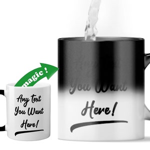 May include: A black and white colour-changing mug with the text "You Want Here!" printed on the white side. The mug is filled with a clear liquid. The text "magic!" is written in green on an arrow pointing to the mug.