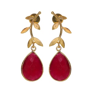 May include: Gold earrings with a leaf design and a teardrop-shaped red gemstone.