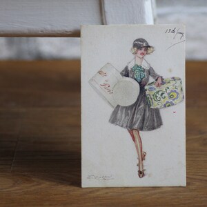 Illustration de fille de carte postale art déco | Dessin de fille avec des boîtes à chapeaux par Mauzan | Non posté | Carte postale antique authentique | Italie, années 30