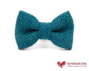 May include: A teal and green herringbone patterned bow tie. The bow tie is made of a textured fabric and is centered on a white background. The bow tie is a pet accessory.