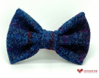 May include: A blue tweed bow tie with flecks of red and purple. The bow tie is a classic shape, with a textured surface. The bow tie is a pet accessory.