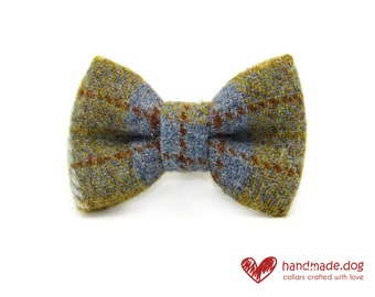 May include: A blue, brown, and yellow plaid bow tie. The bow tie is made of a textured fabric and is set against a white background. The bow tie is a pet accessory.