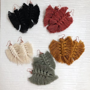 Puede incluir: Conjunto de 5 pares de pendientes de borla hechos a mano en varios colores, incluyendo negro, rojo, blanco, marrón y verde. Cada par presenta un diseño único con múltiples capas de borlas.