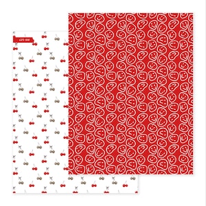 Könnte beinhalten: Zwei Blätter Papier mit Muster. Ein Blatt hat einen weißen Hintergrund mit roten Kirschen und braunen Stielen. Das andere Blatt hat einen roten Hintergrund mit einem weißen Smiley-Gesichtsmuster. Das obere linke Blatt hat den Text "C25-016".