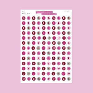 May include: Sheet of round alphabet stickers in shades of pink, burgundy, and green. The stickers are arranged in a grid pattern, with each letter of the alphabet represented multiple times. Text at the top reads "LETTERS & MORE" and "BADIE'S STICKERS."