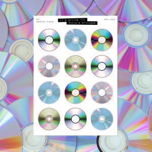 Puede incluir: Una hoja de pegatinas con diseños de discos compactos con superficies iridiscentes. Las pegatinas tienen una variedad de colores, incluyendo azul, plata y oro. El texto "IT'S GIVING Y2K SADIE'S STICKERS" está impreso.