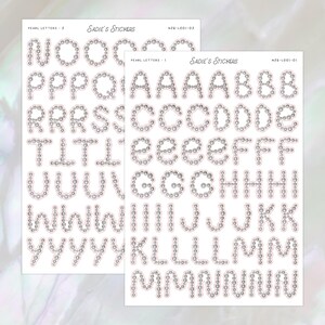 Puede incluir: Dos hojas de pegatinas con el alfabeto, cada letra delineada con pequeñas cuentas plateadas. Las pegatinas están etiquetadas como "Pearl Letters" y "Sadie's Stickers".