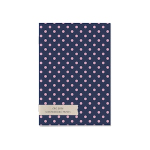 May include: A rectangular pack of scrapbooking papers featuring a dark navy blue background with a repeating pattern of small light pink polka dots. A beige paper label is attached to the bottom, printed with the text CPC 2026 SCRAPBOOKING PAPERS.