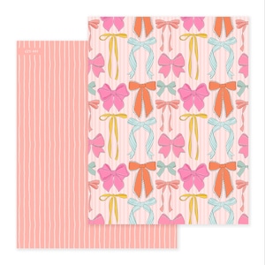 May include: Two sheets of patterned paper. One sheet features a repeating pattern of bows in pink, orange, yellow, and blue on a light pink striped background. The other sheet has a vertical striped pattern in light pink. The text "C25-001" is in the corner.
