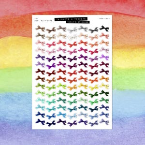 May include: A sheet of mini rainbow bow stickers in a variety of colours, including brown, pink, red, purple, orange, yellow, green, blue, and grey. The sheet has the text "TRINKETS & TIDBITS" and "BADIE'S STICKERS".