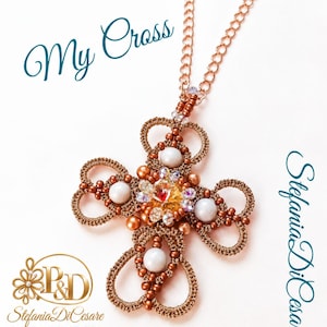 Può includere: Un ciondolo a croce in pizzo chiacchierino color rame su una catenina abbinata, decorato con perle bianche, piccole perline color rame e un cristallo centrale color ambra. Il testo "My Cross" e "Stefania DiCesare Original Jewels Design Chiacchierino" è visibile.