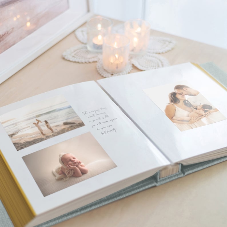 May include: Open photo album with family photos. The album is open to a spread with two photos and a quote. The photos show a family at the beach and a newborn baby. The album has a light blue cover and gold edges.
