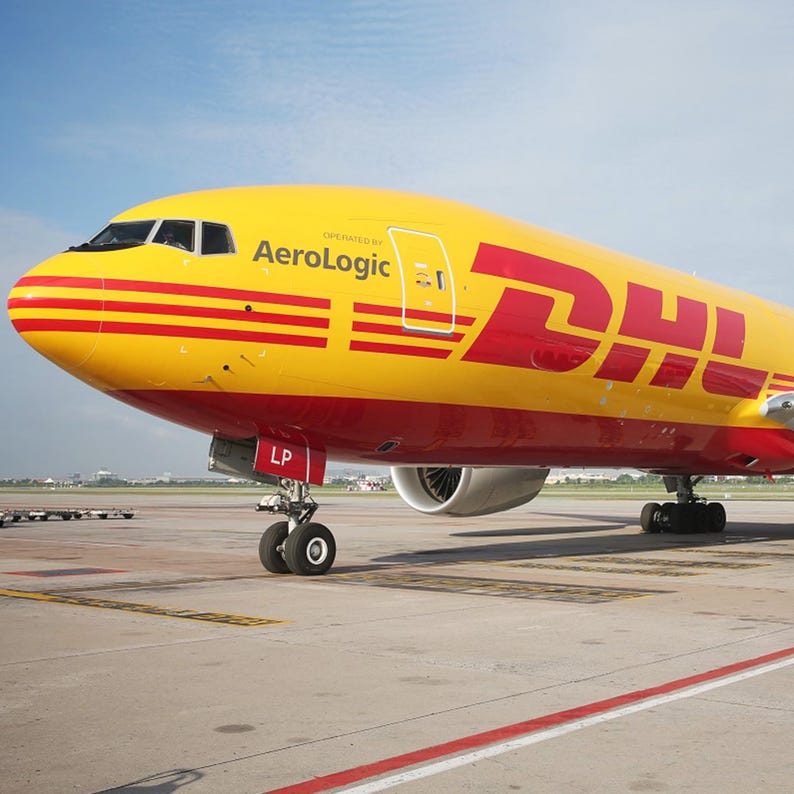 May include: A yellow and red DHL cargo plane with the text "Operated by AeroLogic" on the side. The plane is on the tarmac at an airport.