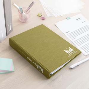 May include: An olive green three-ring binder with a textured fabric-like cover. The front cover and spine feature the white SparkTech logo and the text "Igniting your digital journey." The binder is closed and positioned on a light-coloured surface.