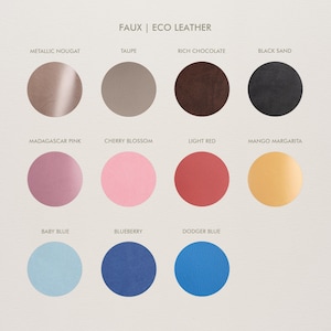 May include: A colour chart titled FAUX | ECO LEATHER displaying eleven circular swatches in various shades: metallic nougat, taupe, rich chocolate, black sand, Madagascar pink, cherry blossom, light red, mango margarita, baby blue, blueberry, and dodger blue.