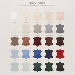 May include: A color chart of Nappa leather swatches in various shades, including white, beige, brown, blue, and black. The text at the top reads "Nappa Leather" and describes the leather's origin and feel.