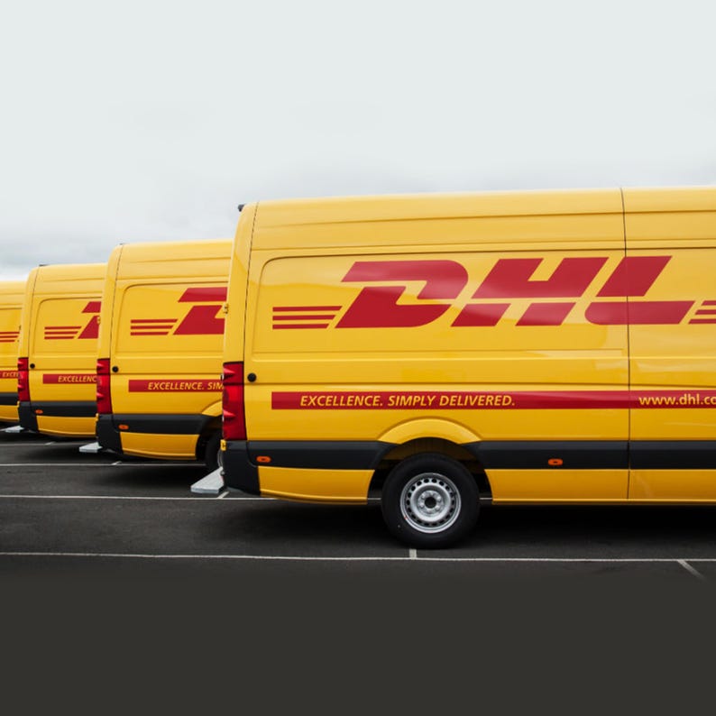 May include: A row of yellow delivery vans with the DHL logo and the slogan "Excellence. Simply Delivered." The vans are parked in a row, with the front of the vans facing the viewer.