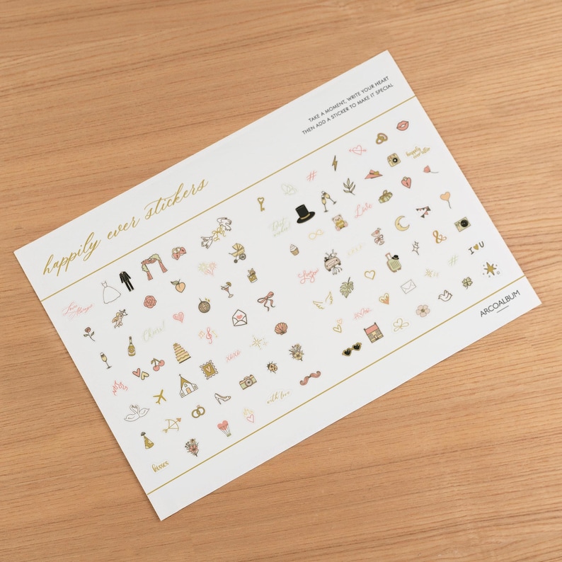 Pode incluir: Uma folha de autocolantes com tema de casamento. Os autocolantes apresentam v&aacute;rias ilustra&ccedil;&otilde;es, incluindo uma noiva e um noivo, cora&ccedil;&otilde;es, ta&ccedil;as de champanhe e as palavras "happily ever stickers". A folha tem detalhes e texto dourados.
