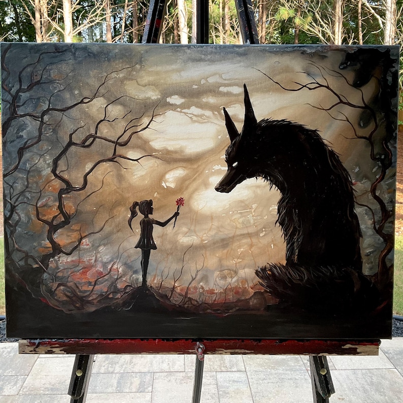 May include: An original painting on canvas depicting a dark fantasy scene. A silhouetted girl offers a red flower to a large, menacing black wolf. The background features a muted, cloudy sky and bare trees, creating a mysterious atmosphere.