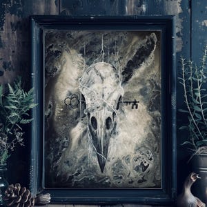 May include: A black framed painting featuring a white and grey skull with a key in its beak. The skull is surrounded by a white, string-like substance.
