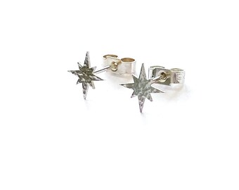 May include: A pair of silver star-shaped stud earrings with a hammered texture.