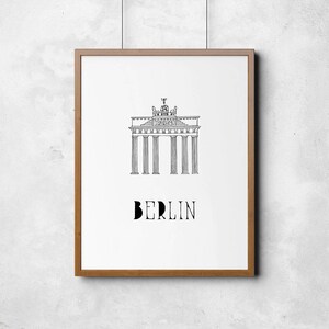 May include: A black and white line drawing of the Brandenburg Gate in Berlin, Germany. The text "BERLIN" is below the gate.