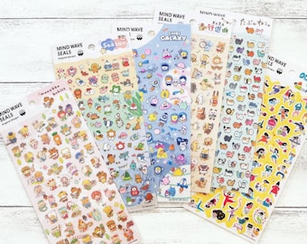 May include: A set of eight colorful sticker sheets featuring various designs, including a galaxy, a cat, a season, and a group of babies. The sticker sheets are all rectangular and have a white background. The text on the sticker sheets reads "Mind Wave Seals" and "Chibi Galaxy".