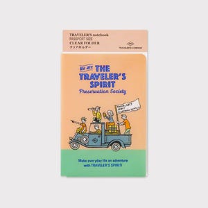 Könnte beinhalten: Ein durchsichtiger Ordner im Passformat mit einem Farbverlauf von Orange nach Grün. Auf der Vorderseite steht der Text "We are THE TRAVELER'S SPIRIT Preservation Society" und eine Illustration von Personen auf einem Oldtimer-Lkw. Oben steht der Text "TRAVELER'S notebook PASSPORT SIZE CLEAR FOLDER".