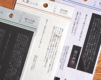 May include: Three clear plastic sheets with black text and images. The sheets are labeled "Literary Seal" and feature Japanese text and images of cats and pens. The text on the sheets includes "The Cat's Pride", "Love Corridor", and "The Dice's Flash".