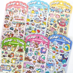 以下が含まれることがあります： Pump Townと書かれた6枚の縦型ステッカーシート。様々な漫画の動物、食べ物、家庭用品、宇宙をテーマにしたイラストが、パステルカラーや鮮やかな色使いでグリッド状に配置されています。