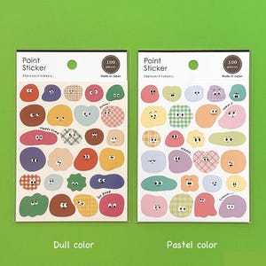 Könnte beinhalten: Zwei Stickerbögen mit bunten, cartoonartigen Formen und Gesichtern. Jedes Blatt enthält 100 Stück und ist mit "Point Sticker" beschriftet. Ein Bogen ist mit "Dull color" beschriftet, der andere mit "Pastel color". Hergestellt in Japan.