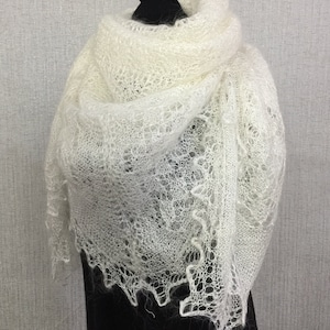 May include: A white lace shawl with a delicate, intricate pattern. The shawl is made of a soft, lightweight fabric and has a flowing, elegant drape.