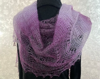May include: A delicate, hand-knitted shawl in a gradient of purple and white. The shawl is made of a soft, lightweight yarn and has a lacy, openwork design.