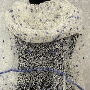 May include: White lace shawl with blue beaded accents. The shawl is delicate and has a delicate, openwork design.
