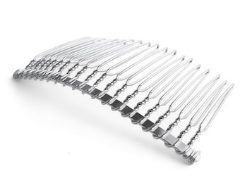 May include: Silver metal hair comb with a curved shape and a twisted wire design. The comb has 18 teeth.