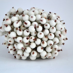 May include: A cluster of white berries with red centers, perfect for adding a touch of wintery charm to your holiday decor.