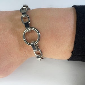 Könnte beinhalten: Ein silbernes Kettenarmband mit einem großen, runden, offenen Glied.
