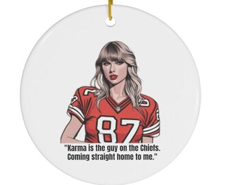 Peut inclure: Une décoration de Noël en céramique blanche avec un maillot de football rouge et blanc portant le numéro 87. La décoration est munie d'une ficelle dorée pour l'accrocher et le texte "Karma is the guy on the Chiefs. Coming straight home to me."